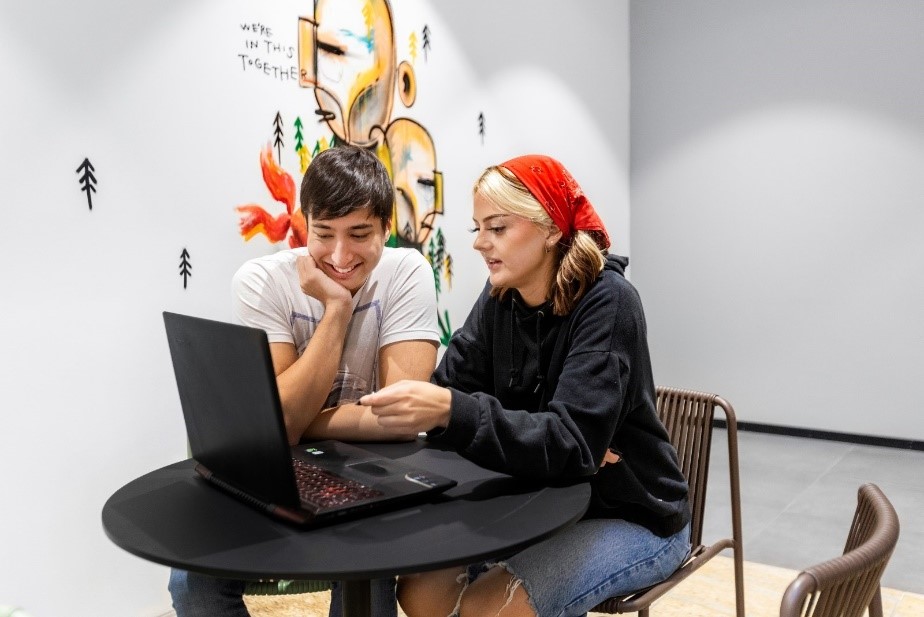 A person and person looking at a computer

Description automatically generated